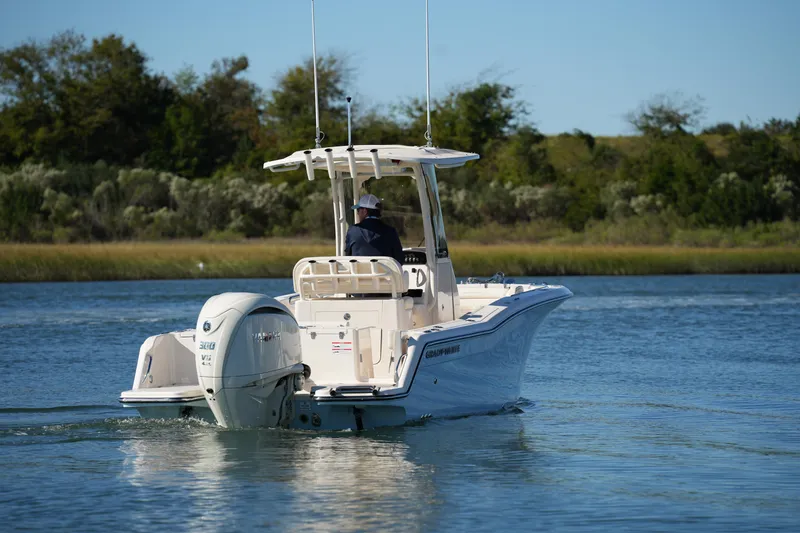 Slide: The Image of 2024 Grady-White Fisherman 236 boat cruising on a calm lake with lush greenery. - 12