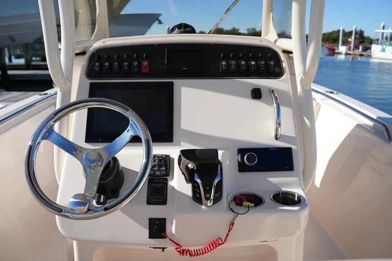 Slide: The Image of 2024 Grady-White Fisherman 236 boat console with steering wheel and controls. - 24