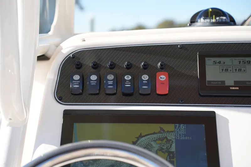 Slide: The Image of 2024 Grady-White Fisherman 236 dashboard with control switches and digital display. - 26
