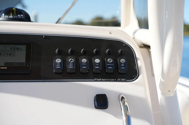 Slide: The Image of 2024 Grady-White Fisherman 236 dashboard with control switches and display screen. - 27