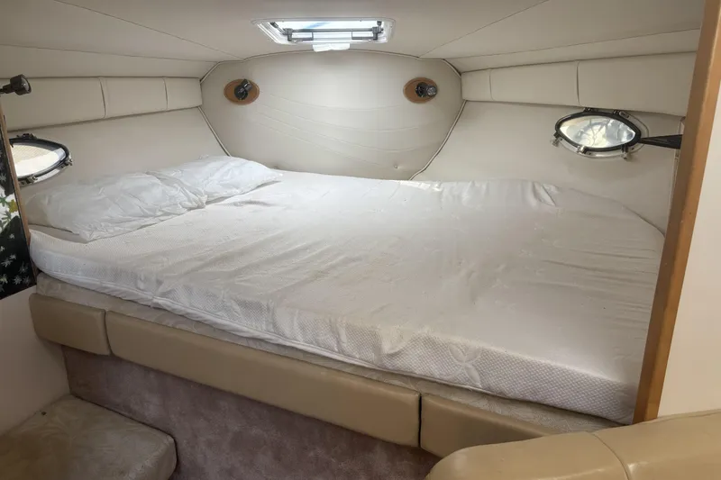 Slide: The Image of Interior cabin of 2000 Larson Cabrio 330 Mid Cabin with cozy bed and portholes. - 27
