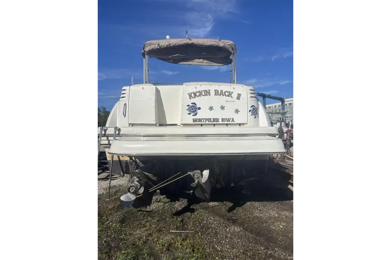 Slide: The Image of 2000 Larson Cabrio 330 Mid Cabin boat, rear view, on land, clear sky. - 3