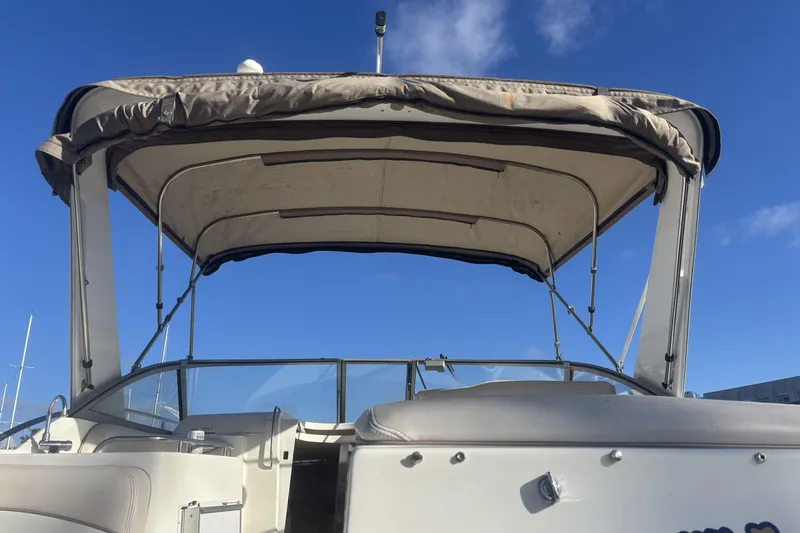Slide: The Image of 2000 Larson Cabrio 330 Mid Cabin boat with canopy under clear blue sky. - 35