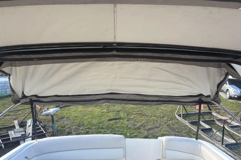 Slide: The Image of 2000 Larson Cabrio 330 Mid Cabin boat with open canopy and seating area. - 36