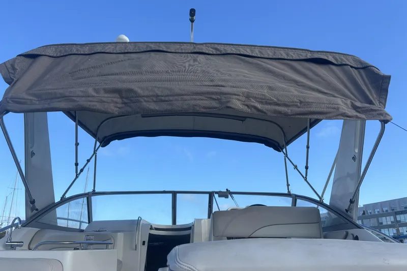 Slide: The Image of 2000 Larson Cabrio 330 Mid Cabin boat with canopy under clear blue sky. - 37