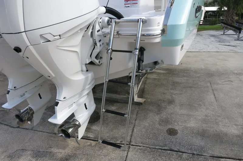Slide: The Image of 2025 Robalo R250 Center Console boat with dual outboard motors and swim ladder. - 12