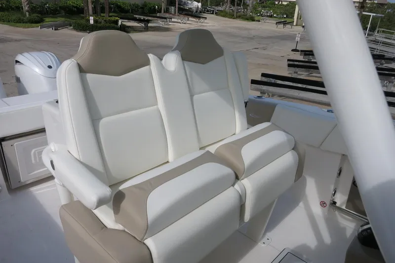 Slide: The Image of 2025 Robalo R250 Center Console boat with dual beige and white cushioned seats. - 23