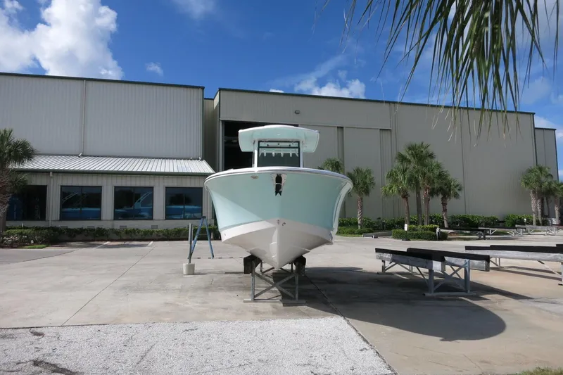 Slide: The Image of 2025 Robalo R250 Center Console boat displayed outside a large warehouse. - 3