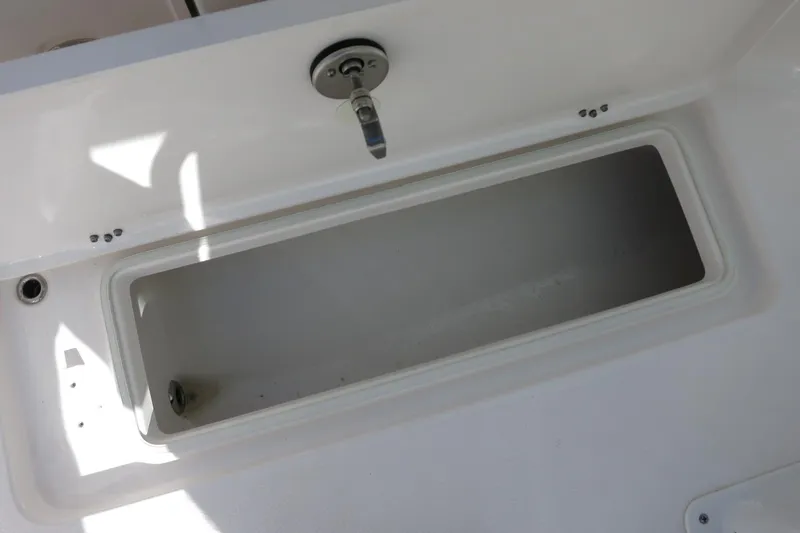 Slide: The Image of 2025 Robalo R250 Center Console storage compartment, open and empty. - 30