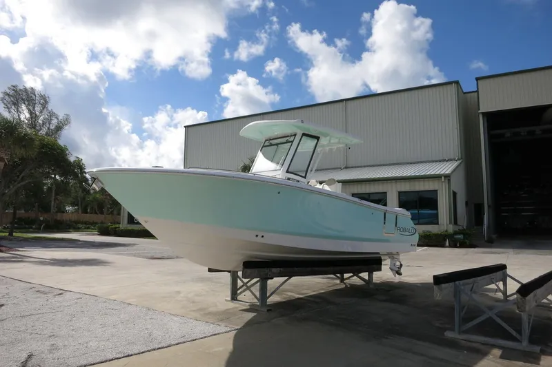Slide: The Image of 2025 Robalo R250 Center Console boat on display outside a warehouse. - 4