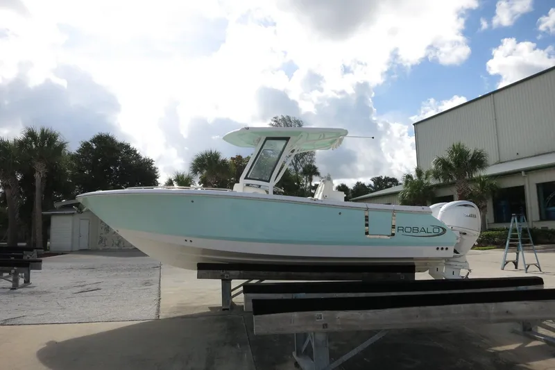 Slide: The Image of 2025 Robalo R250 Center Console boat on display outdoors, under a cloudy sky. - 5