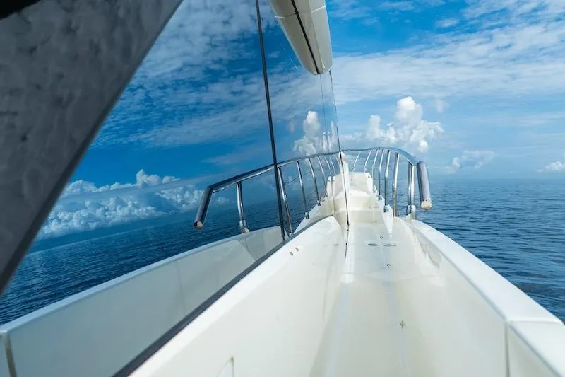 Slide: The Image of 2023 Absolute 62 Fly yacht reflecting ocean and sky, showcasing sleek design. - 13