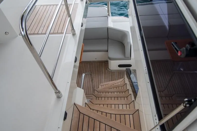 Slide: The Image of Luxurious 2023 Absolute 62 Fly yacht interior with wooden stairs and seating area. - 18