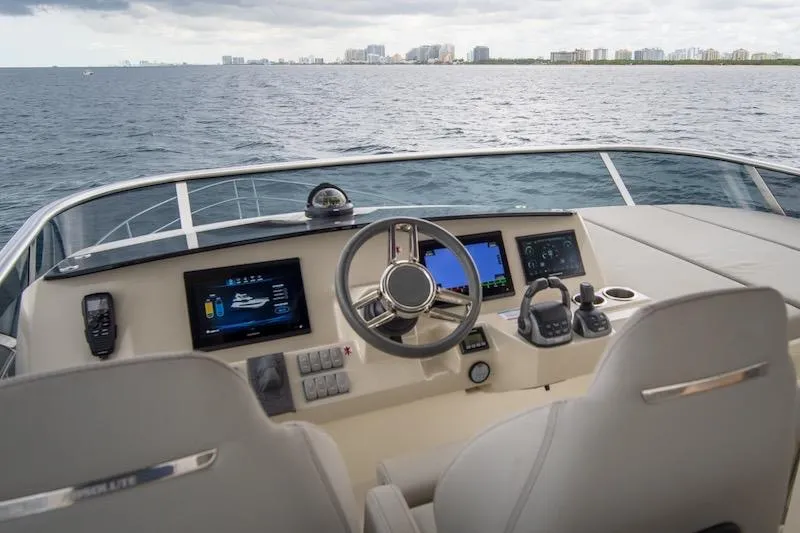 Slide: The Image of 2023 Absolute 62 Fly yacht helm with modern navigation systems, steering wheel, and ocean view. - 26