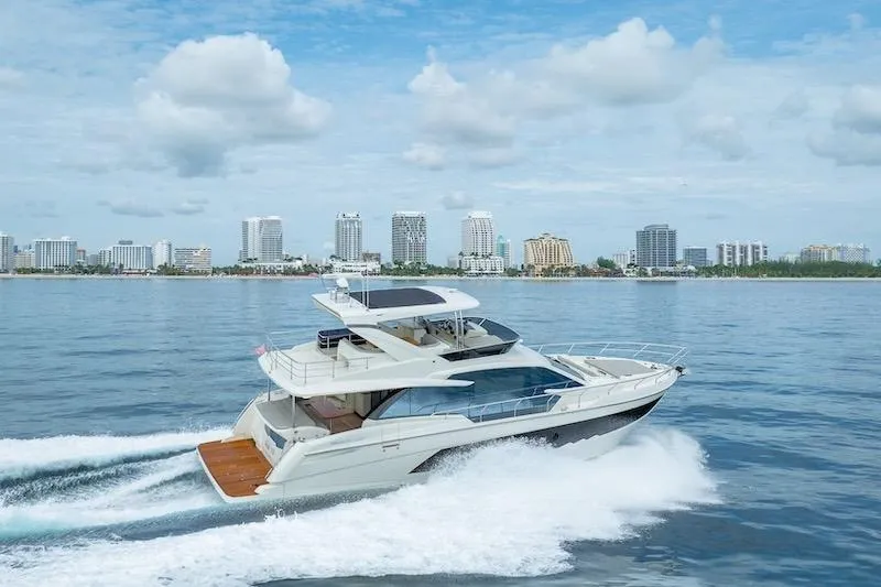 Slide: The Image of 2023 Absolute 62 Fly yacht cruising near city skyline on a sunny day. - 5
