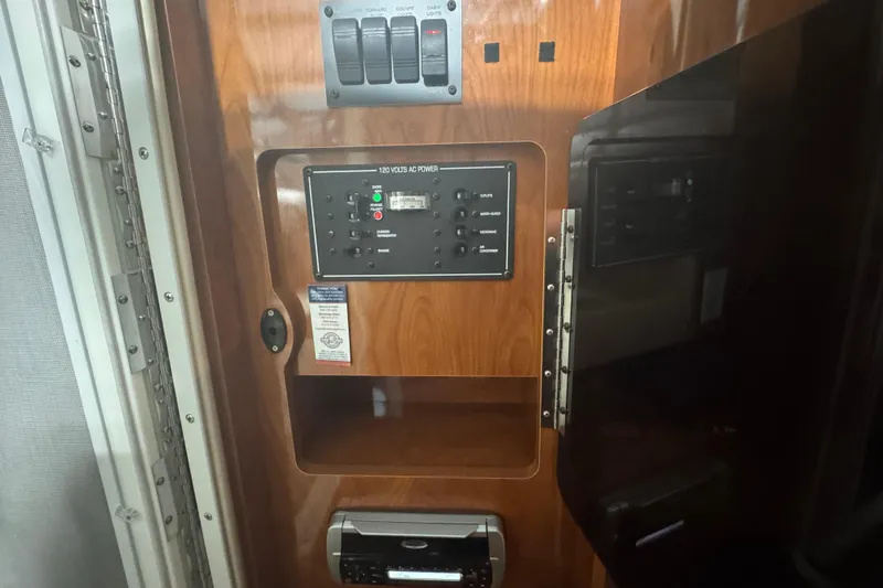 Slide: The Image of 2004 Four Winns 268 Vista interior control panel with wood finish and electrical switches. - 19