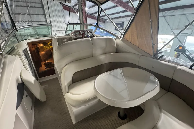 Slide: The Image of 2004 Four Winns 268 Vista boat interior with seating and table in a covered dock. - 3