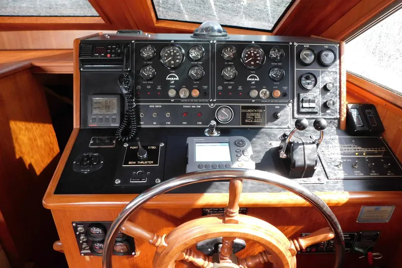 Slide: The Image of 1995 Jefferson 52 Riviana Cockpit MY helm with gauges, controls, and wooden steering wheel. - 30