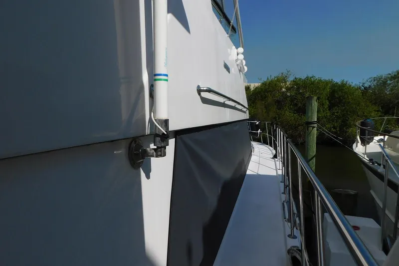 Slide: The Image of Side view of 1995 Jefferson 52 Riviana Cockpit MY yacht docked by greenery. - 41