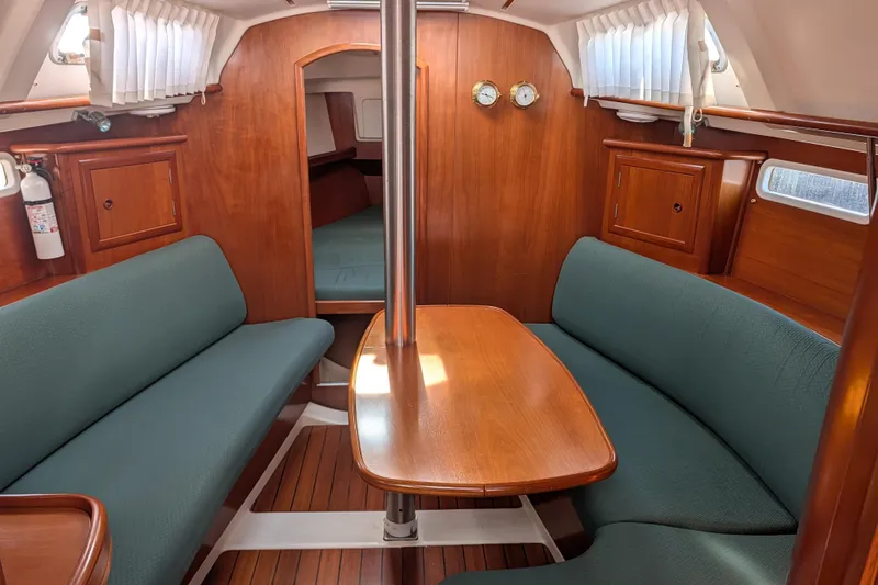 Slide: The Image of Interior of 2001 Beneteau Oceanis 331 sailboat with wood finish and green seating. - 1