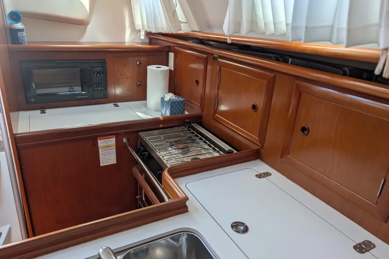 Slide: The Image of Beneteau Oceanis 331 yacht kitchen with wood cabinetry, microwave, and stove, 2001 model. - 3
