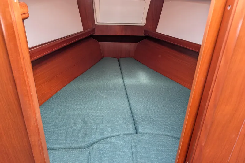 Slide: The Image of Interior cabin of 2001 Beneteau Oceanis 331 sailboat with wooden finish and green cushions. - 4