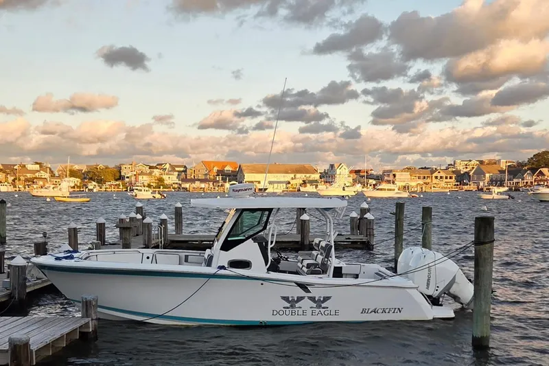 The Image of 2018 Blackfin 272 CC boat docked at a scenic harbor with cloudy sky. - 0