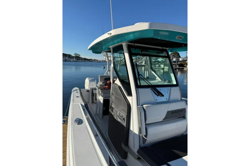 Slide: The Image of 2018 Blackfin 272 CC boat docked by calm waters under clear blue sky. - 19