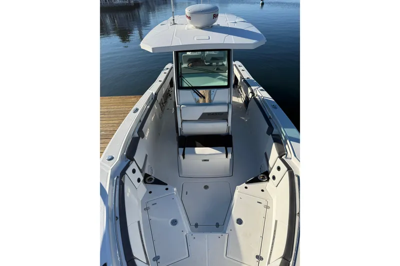 Slide: The Image of 2018 Blackfin 272 CC boat interior, featuring spacious seating and sleek design on calm water. - 20