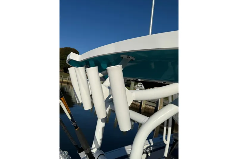 Slide: The Image of 2018 Blackfin 272 CC boat with rod holders, docked under clear blue sky. - 23
