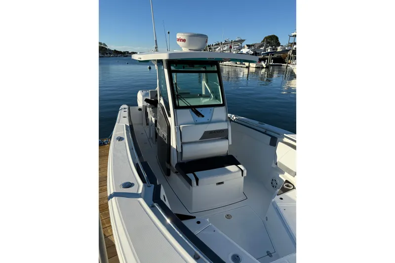 Slide: The Image of 2018 Blackfin 272 CC boat docked in a marina, showcasing sleek design and spacious deck. - 34