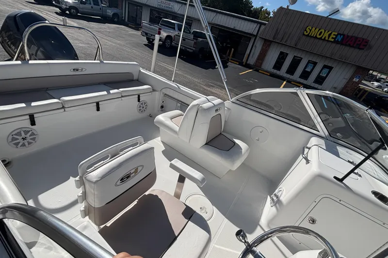 Slide: The Image of 2013 Sea Hunt Escape 188 boat interior with seating, parked near a store. - 19