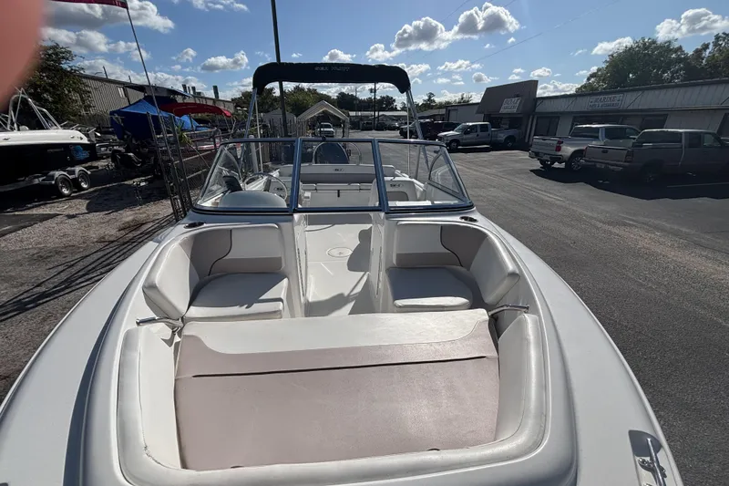 Slide: The Image of 2013 Sea Hunt Escape 188 boat with seating, parked outdoors under a sunny sky. - 7