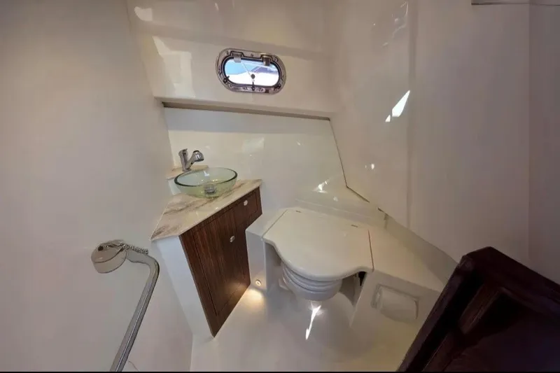 Slide: The Image of 2024 Pursuit OS 325 Offshore boat bathroom with modern sink and compact toilet. - 11