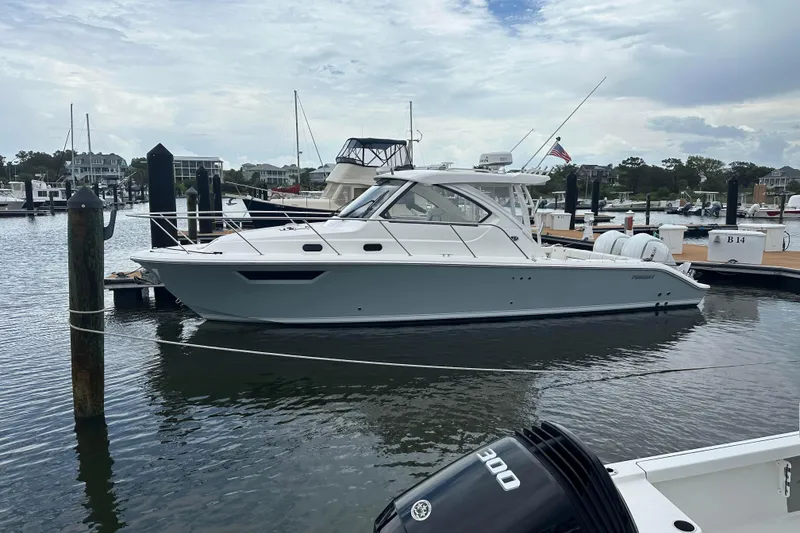 Slide: The Image of 2024 Pursuit OS 325 Offshore boat docked in a marina, side view. - 3