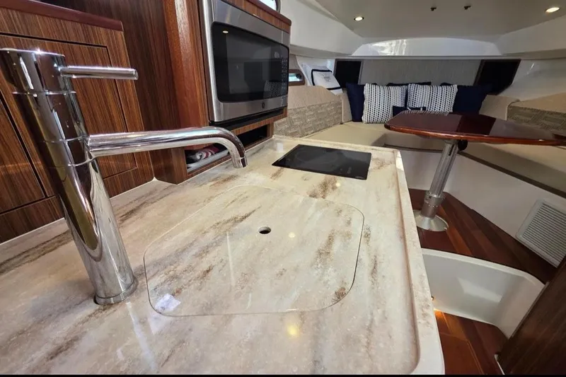 Slide: The Image of 2024 Pursuit OS 325 Offshore interior with modern kitchen and cozy seating area. - 6