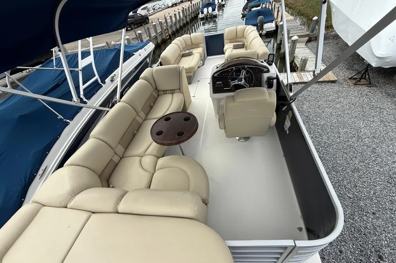 Slide: The Image of 2018 SouthWind V23 L pontoon boat with beige seating and a central steering console. - 12