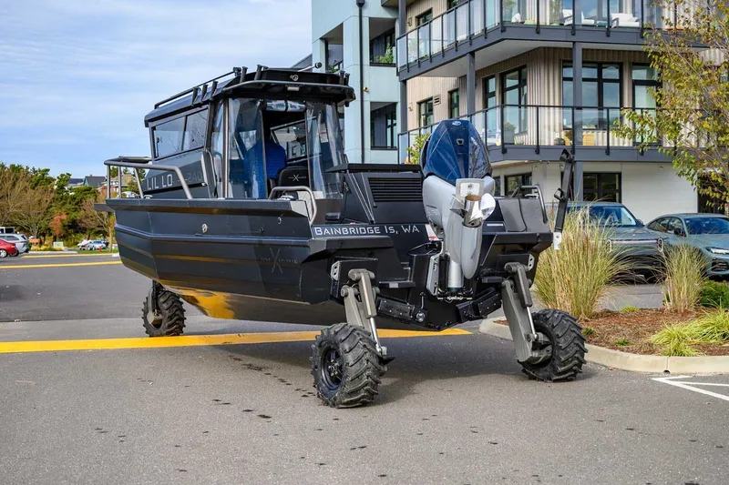 Slide: The Image of Amphibious StabiX 240UCC boat with wheels, 2024 model, parked near modern building. - 8