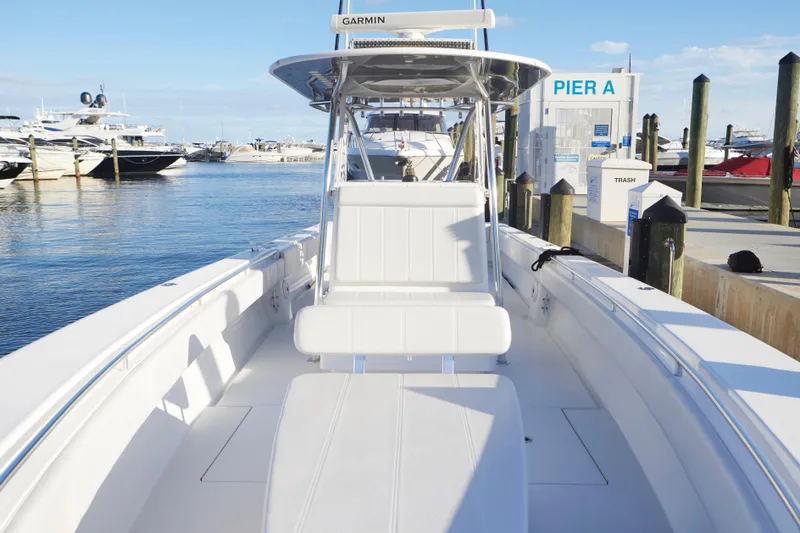 Slide: The Image of 2014 Contender 39 ST boat docked at marina, featuring spacious seating and Garmin equipment. - 11