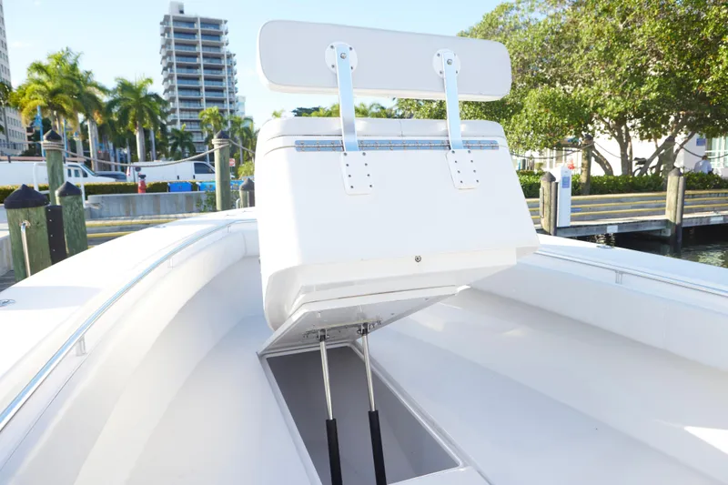 Slide: The Image of 2014 Contender 39 ST boat with open storage compartment, docked near palm trees. - 12
