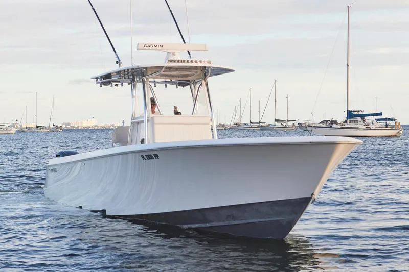 Slide: The Image of 2014 Contender 39 ST boat cruising on calm waters with sailboats in the background. - 7