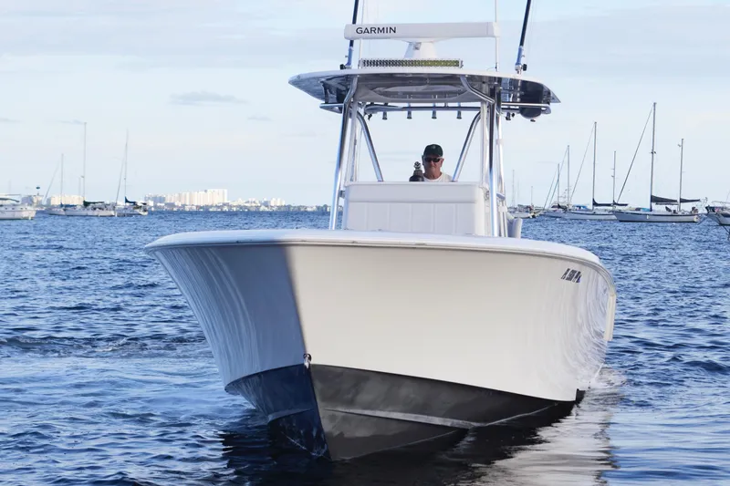 Slide: The Image of 2014 Contender 39 ST boat cruising on a calm sea with distant sailboats. - 8