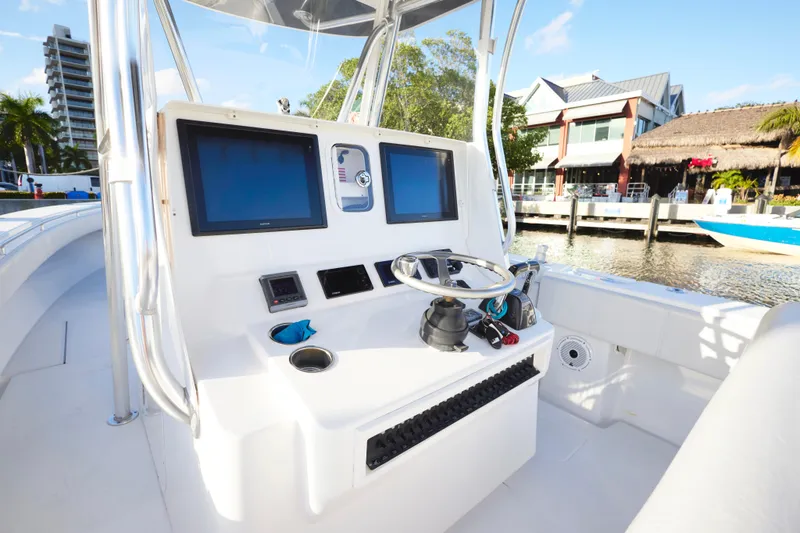 Slide: The Image of 2014 Contender 39 ST boat helm with dual screens and steering wheel, dockside view. - 9