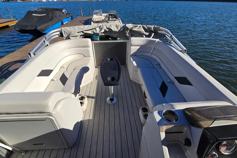 Slide: The Image of 2023 G3 Select 22RC pontoon boat interior with spacious seating and table on a lake. - 14