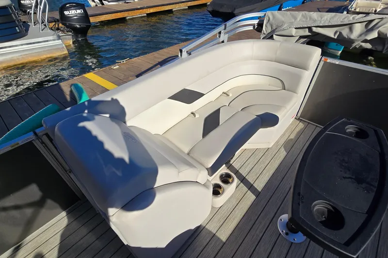 Slide: The Image of 2023 G3 Select 22RC boat interior with plush seating and cup holders on a dock. - 20