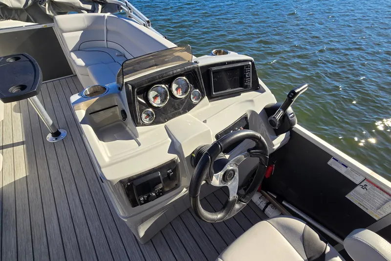 Slide: The Image of 2023 G3 Select 22RC boat dashboard with steering wheel, gauges, and water view. - 26