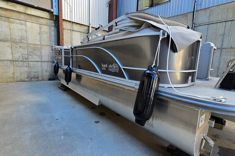 Slide: The Image of 2023 G3 Select 22RC pontoon boat in storage, featuring sleek design and protective fenders. - 53