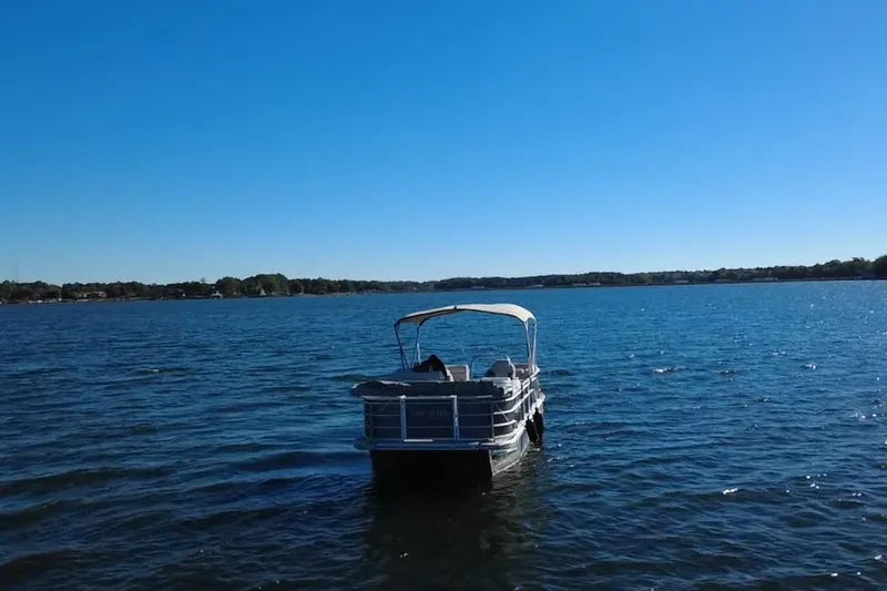 Slide: The Image of 2023 G3 Select 22RC pontoon boat on a serene lake under clear blue skies. - 56
