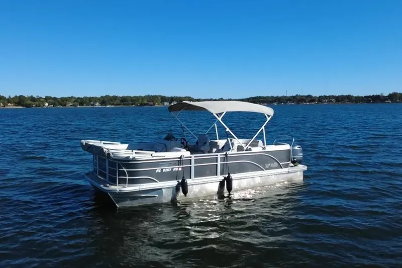 Slide: The Image of 2023 G3 Select 22RC pontoon boat on a calm lake under clear blue skies. - 57