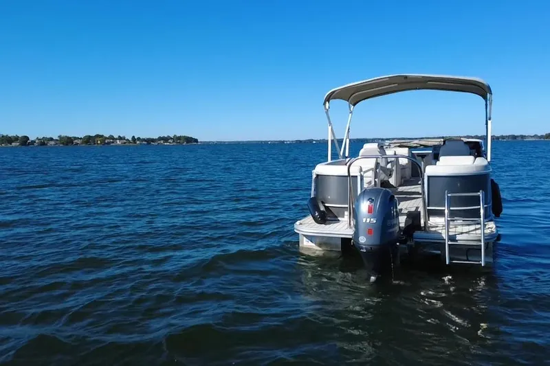 Slide: The Image of 2023 G3 Select 22RC pontoon boat on a calm lake under clear blue sky. - 59
